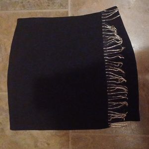 A black skirt with rhinestone fringe.